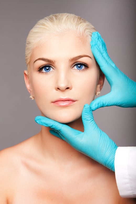 Cosmetic plastic surgeon touching aesthetics face