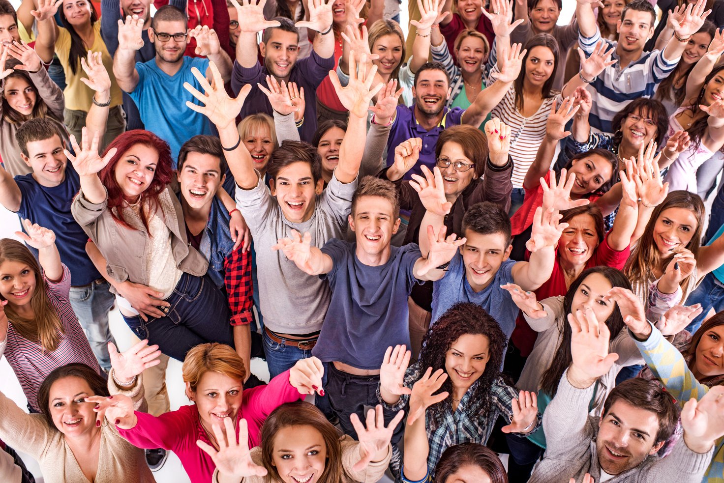 Crowd of cheerful people with raised hands.