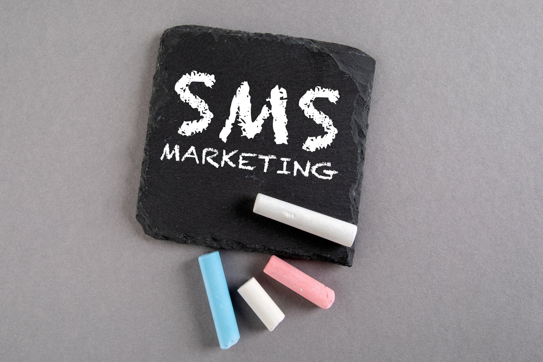 SMS MARKETING. Business concept. Text on a stone surface